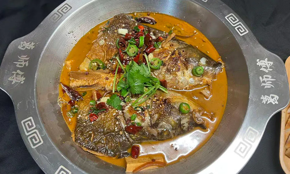 Flavorful fish head stew in rich sauce, served with flatbread at Chef Ge, a Chinese Restaurant in Highland Park